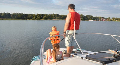 Mann und Kind beim Angeln auf einem Hausboot auf der Mecklenburgischen Seenplatte