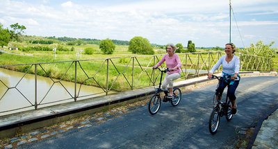 Zwei Frauen radeln über eine Brücke am Canal du Midi